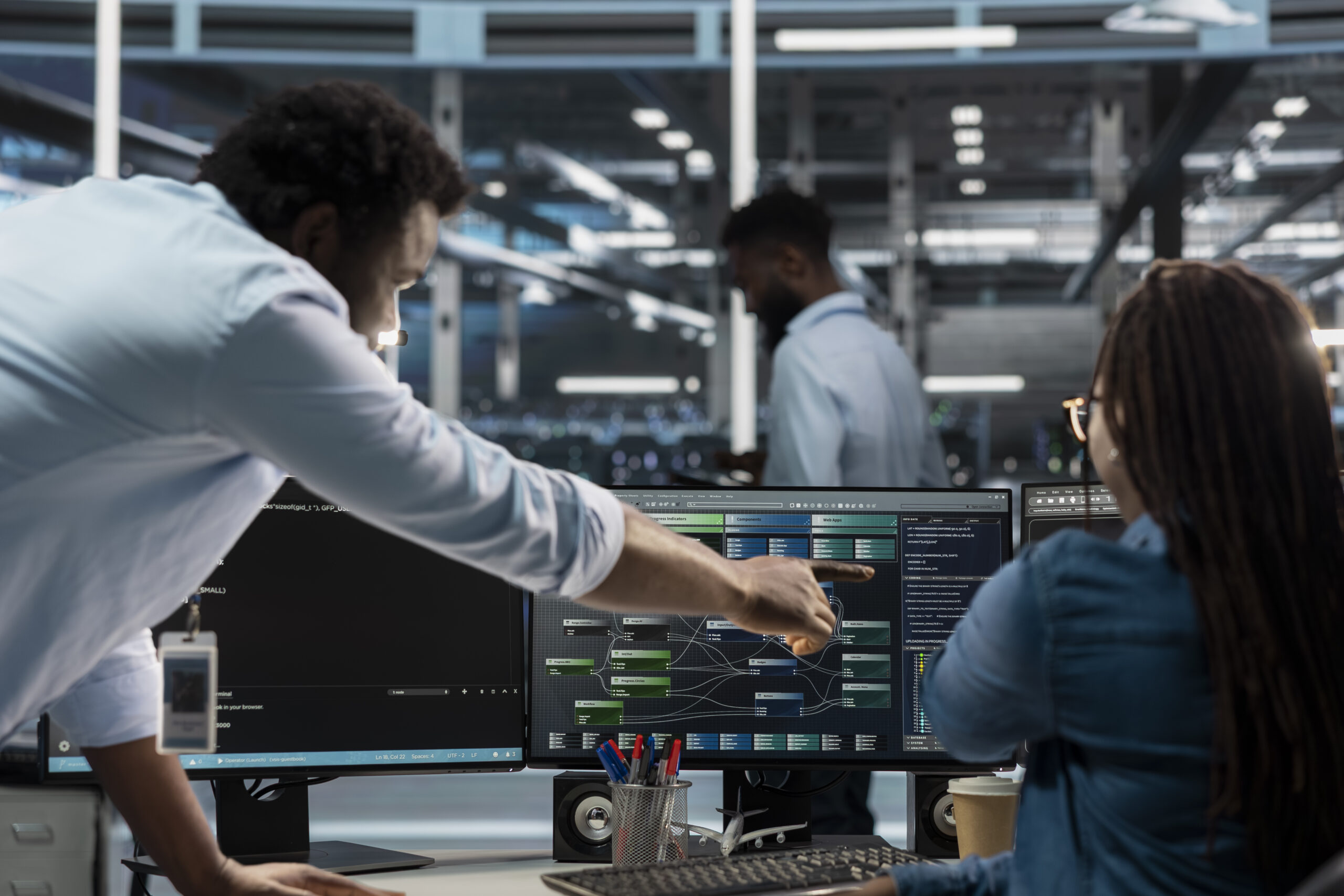 Data center supervisor overseeing admin using PC to visualize AI node trees